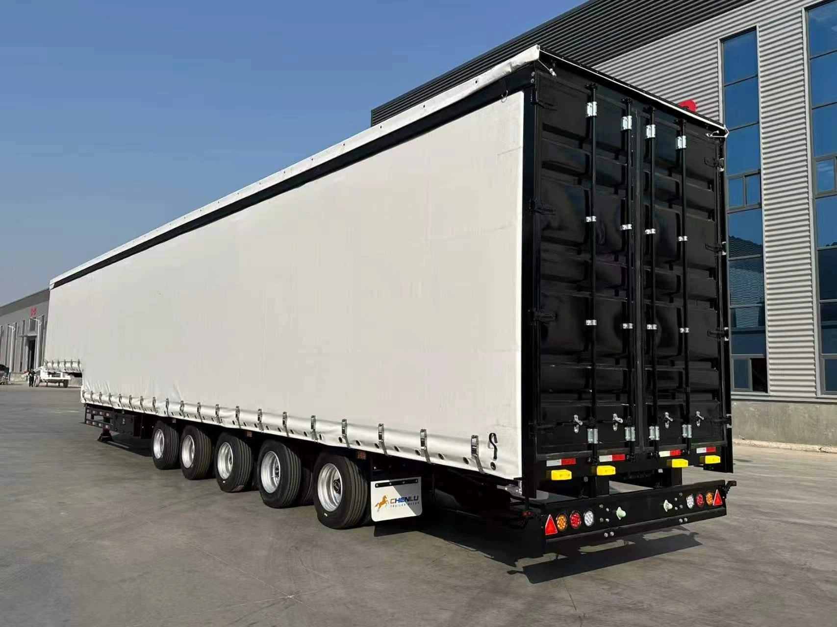 Carrosserie à rideaux blancs et portes arrière doubles noires sur la semi-remorque bâchée à 5 essieux